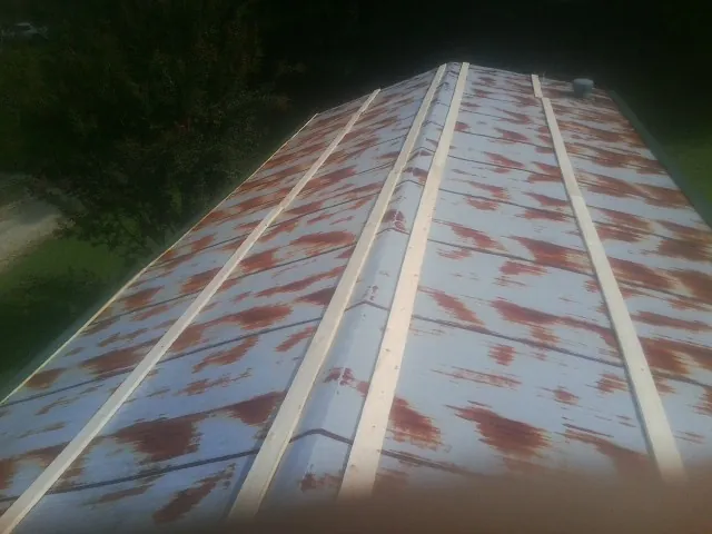 Rusted metal roof panels with new wood purlins before replacement — Storm Damage Roof Repair in Cochrane by Roofing Brothers