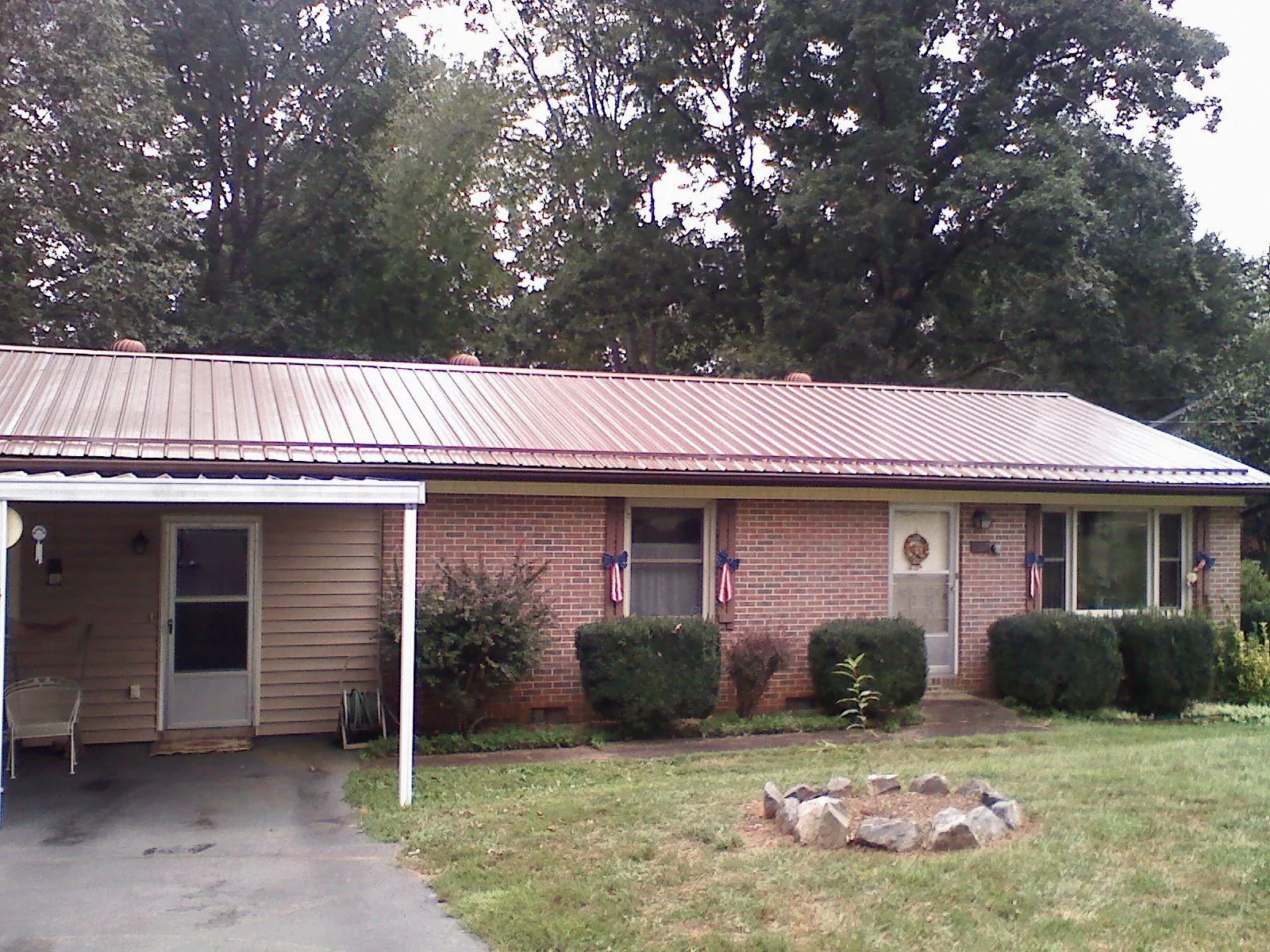 Bronze metal roof and carport on a brick ranch home — Roof Repair work by our crew in Cochrane